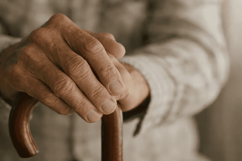 Elderly man hands on cane