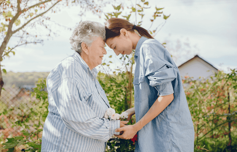 Senior mother holding hands with adult daughter
