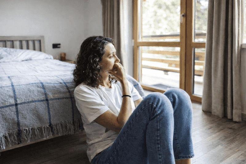 Concerned woman sitting on floor